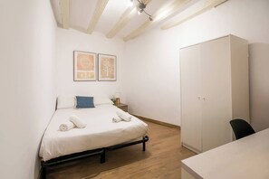Un dormitorio con cama, armario y dos cuadros en la pared.