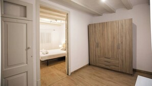 Een kamer met een bed, een houten kledingkast en een deur.