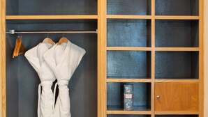 A wooden wardrobe with multiple shelves and a hanging space for robes.