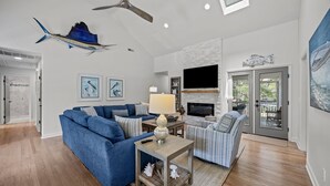 A modern living room with a sectional sofa, a coffee table, and a fireplace. - Modern Beach Home on Quiet Street w/Private Pool. 1 Block to Beach! (Isle Of Palms)