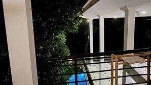 Un balcon avec une balustrade, un arbre et un sol carrelé.