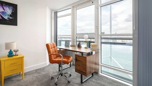A modern office space with a desk, chair, and a yellow side table with a lamp. - Stunning Thames View 2BR Apartment 2 Baths 2 Balconies Sleeps 6 (Greater London)