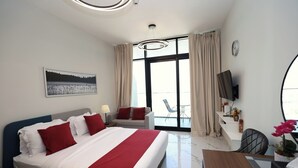 Een moderne hotelkamer met een groot bed, een bureau, een stoel en een balkon met uitzicht.