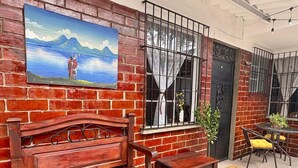 A wooden bench and table set against a brick wall with a painting.