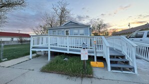 A two-story house with a white deck and a covered porch.
