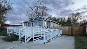 A single-story house with a front porch and a wooden fence.