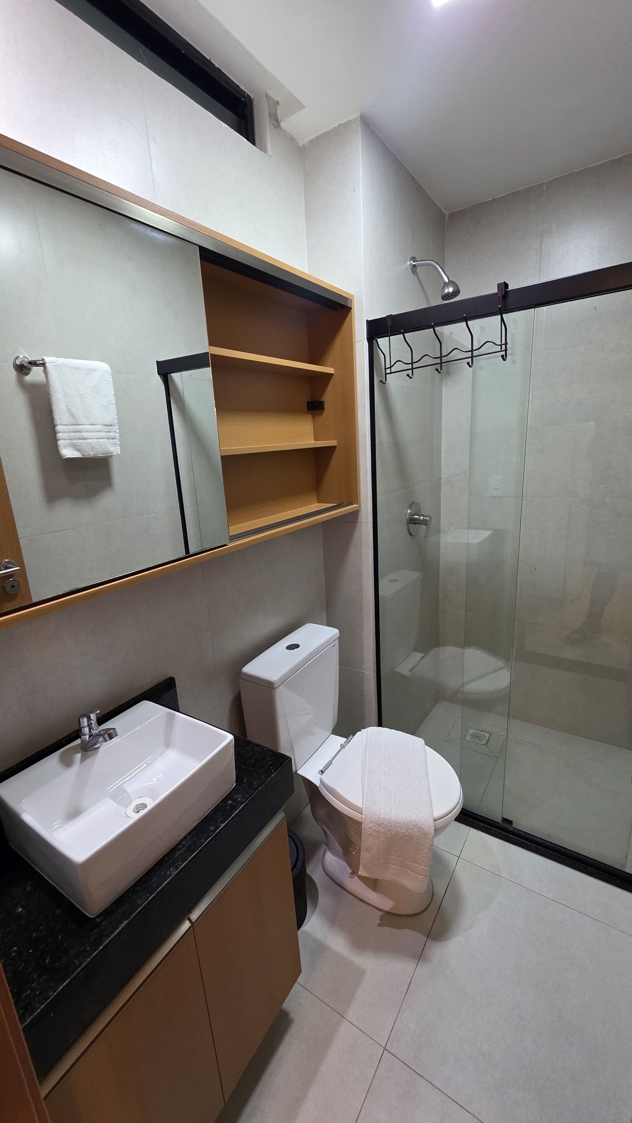 A modern bathroom with a sink, toilet, and glass shower enclosure.