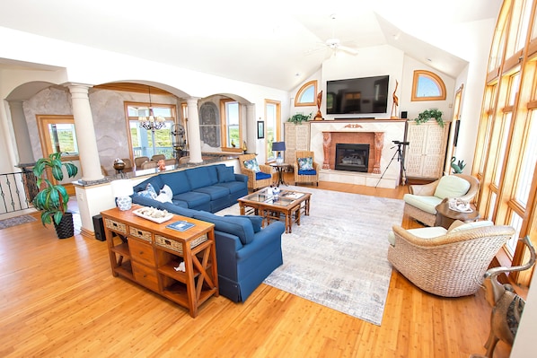 A spacious living room with a large sectional sofa, a fireplace, and a television.