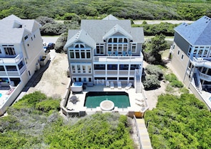 A large two-story house with a swimming pool, multiple decks, and a dock.