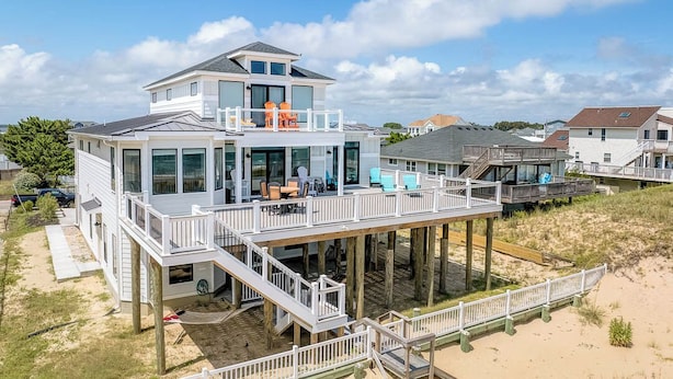 A beachfront house with a large deck, multiple levels, and a covered outdoor area. - A Wave From It All | Oceanfront | Hot Tub (Virginia Beach)
