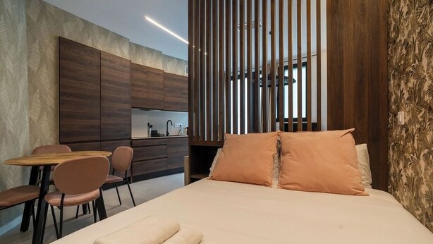 A modern hotel room with a bed, a small dining area, and a kitchenette. - VLC HOST - Palleter 1 (Valencia)