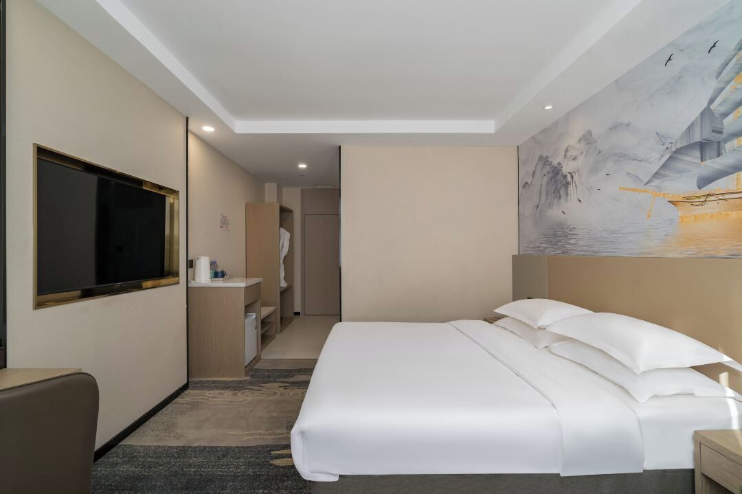Una habitación de hotel con cama, televisión, escritorio y baño.