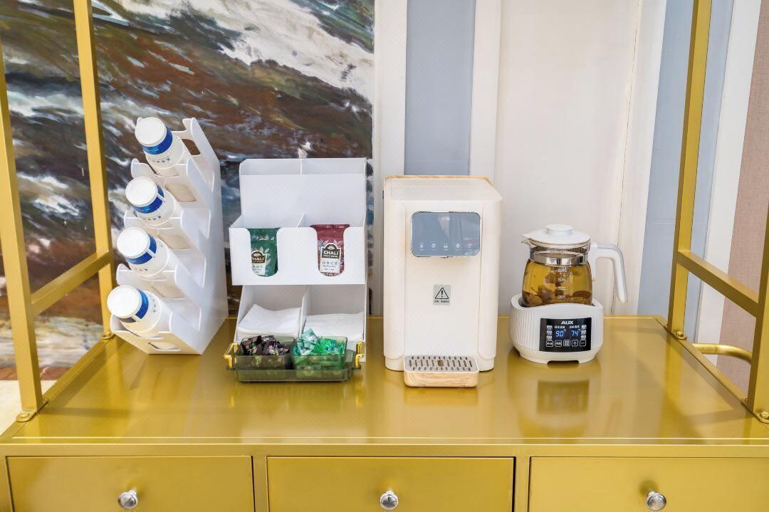 Et tekøkken med kaffemaskine, riskoger og en flaskedispenser.