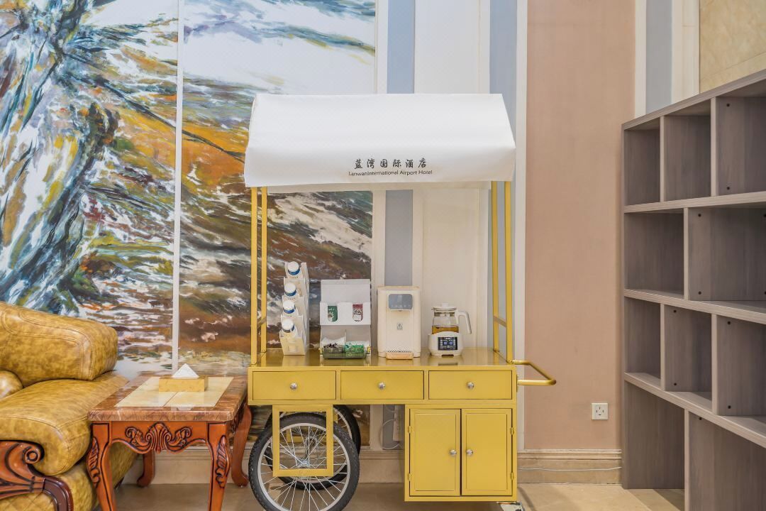 Un kiosque jaune surmonté d’un auvent blanc, un vélo et une machine à café.