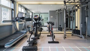 Een sportschool met loopbanden, hometrainers en krachtapparaten.