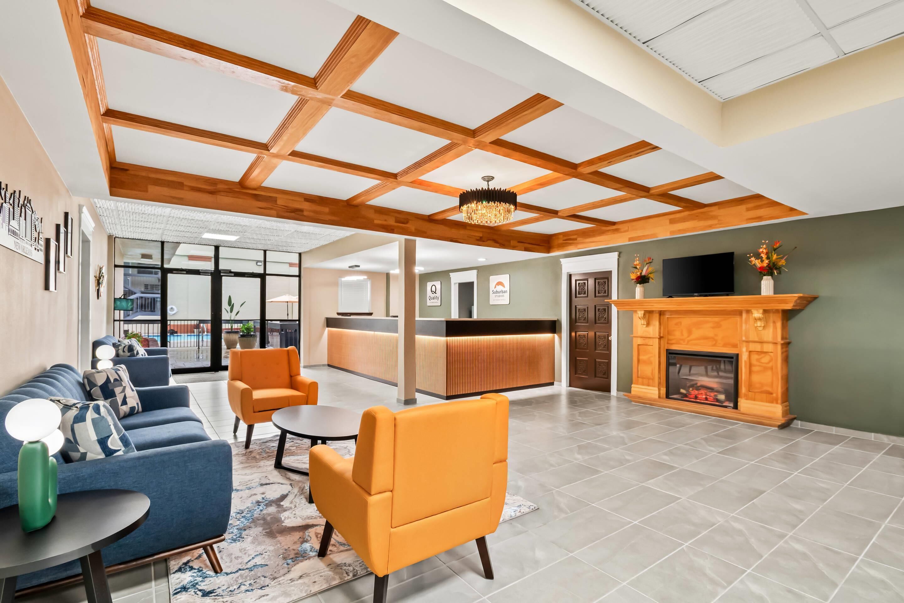 A spacious lobby with a reception desk, seating area, and a fireplace.