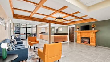 A spacious lobby with a reception desk, seating area, and a fireplace.