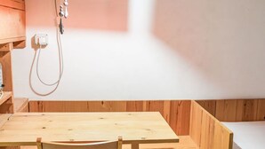 A wooden cabin with a table and chairs, a small bed, and a red light fixture. - Apartment Fazio by Interhome (Strongoli)