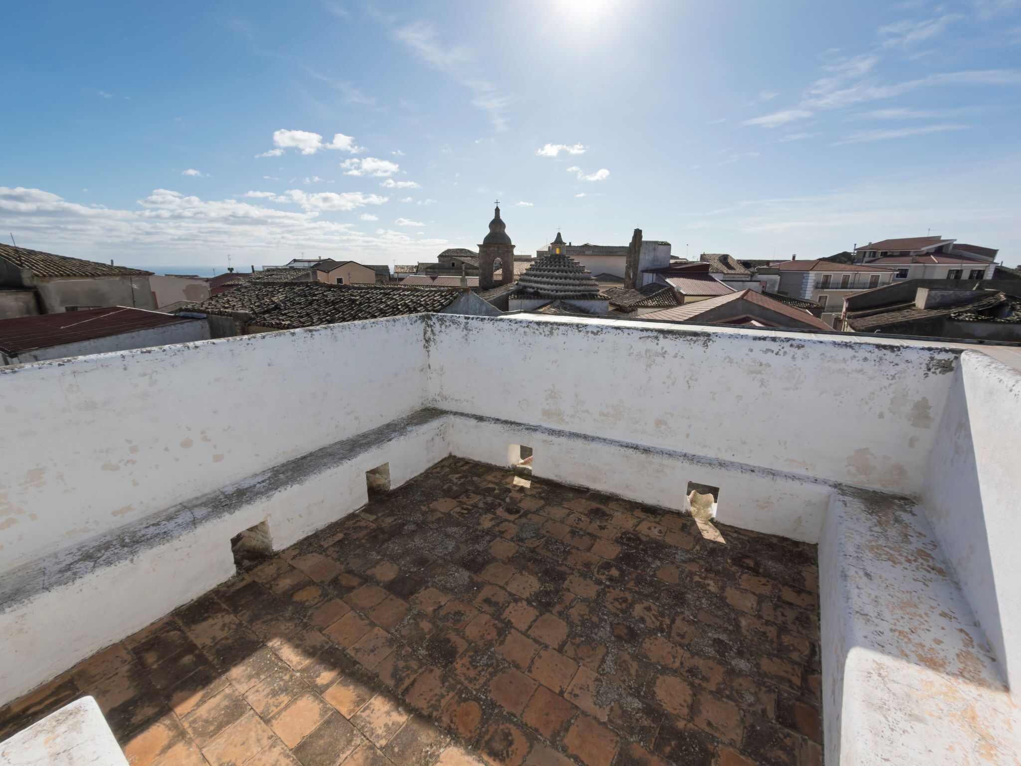 A rooftop terrace with a view of the cityscape, including buildings and a church.