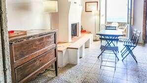 A room with a wooden desk, a chair, a table, a lamp, and a view of the sea. - Apartment Perri by Interhome (Strongoli)