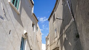 Un carrer estret entre edificis amb un cel blau clar.