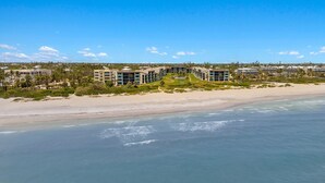 Et hotel ved stranden med flere bygninger, en sandstrand og udsigt over havet.