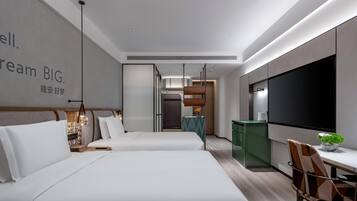 A modern hotel room with two beds, a TV, a desk, and a dining area.