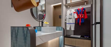 A modern bathroom with a large mirror, a sink, a toilet, and a shower area.