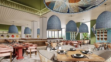 Un amplio vestíbulo de hotel con techos altos, grandes lámparas de techo tejidas y diversas opciones de asientos, incluyendo sofás y sillones.