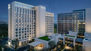 Ein moderner Hotelkomplex mit mehreren Hochhäusern, erkennbar an der auffälligen 'EVEN'-Beschilderung an einem der Gebäude.