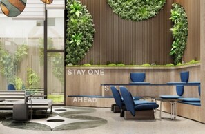 A modern waiting area with a wooden wall, green vertical gardens, and blue seating. - Even Yining By Ihg (Yining)