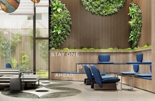 Un área de espera moderna con pared de madera, jardines verticales verdes y asientos azules.