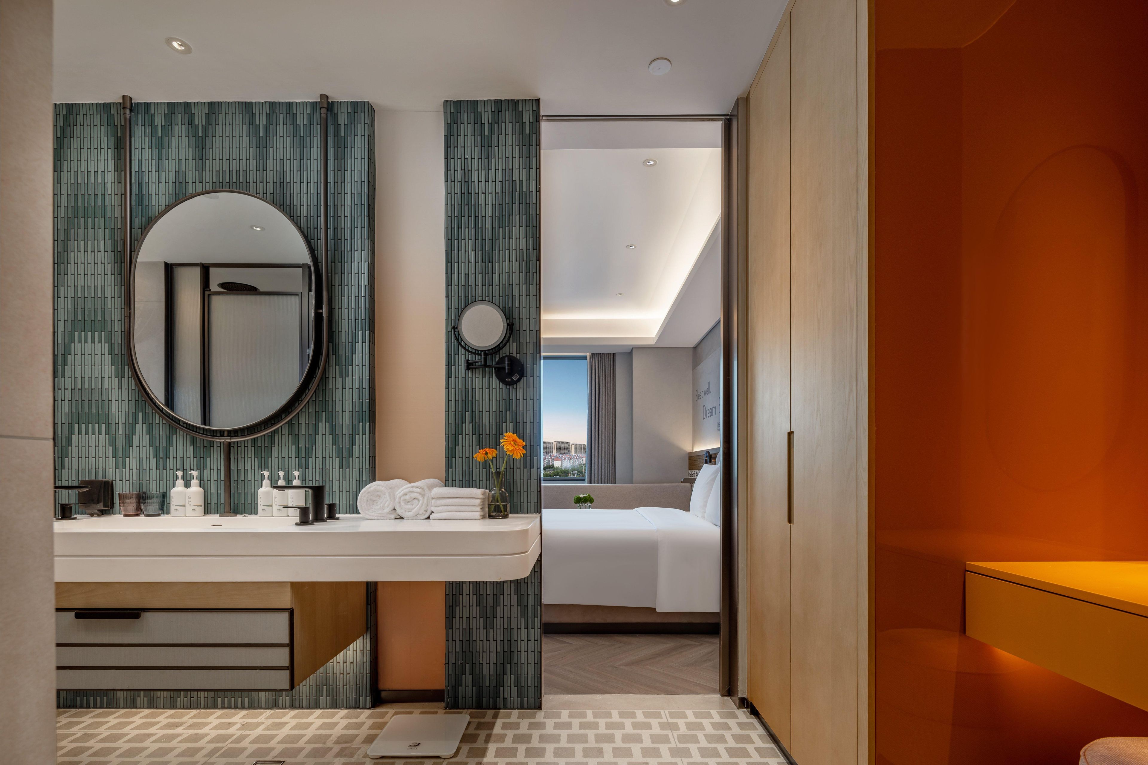 Een moderne hotelkamer met een badkamer, een bed en uitzicht op de stad.