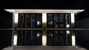 Un bâtiment moderne doté de grandes fenêtres en verre et d’un toit plat, caractérisé par un design minimaliste et une surface réfléchissante.