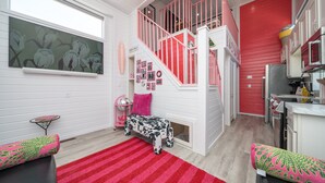 A modern kitchen with white cabinets and a red accent wall. - The Boozy Bungalow at Roadrunner Resort (Parker)
