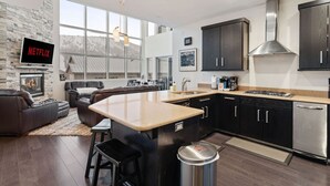 A modern kitchen with dark cabinets, a central island, and a large window. - 3min Walk to Ski Lifts*Movie Theater*Views (Brian Head)