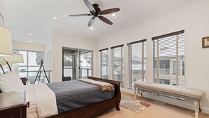 A bedroom with a bed, a ceiling fan, a bench, large windows, and a view of the outdoors. - 3min Walk to Ski Lifts*Movie Theater*Views (Brian Head)