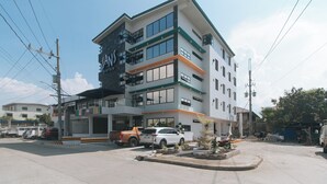 A multi-story hotel with a modern design, featuring balconies and large windows. - Sans Hotel near Enchanted Kingdom (Santa Rosa)