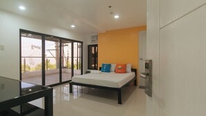 A modern hotel room with a bed, a glass table, and a view of the outside. - Sans Hotel near Enchanted Kingdom (Santa Rosa)