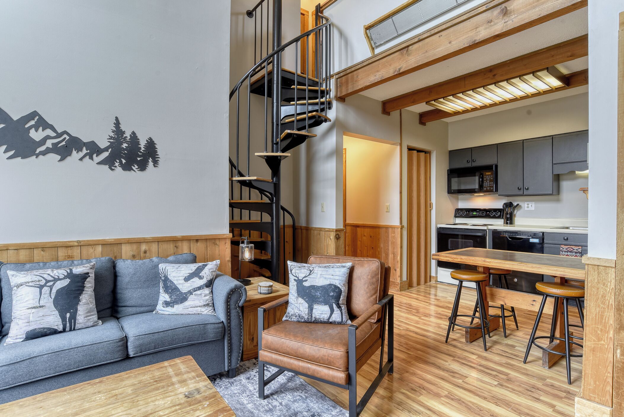 A modern interior with a sofa, a chair, a bar area, and a kitchen.