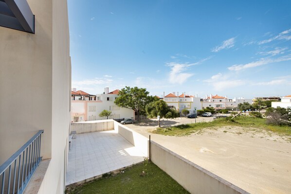 A residential area with a view of houses, a paved courtyard, and a clear sky.