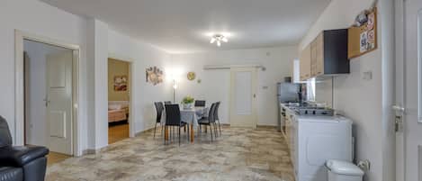 A compact living space with a dining area, a kitchen, and a laundry area.