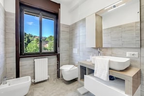 A modern bathroom with a bathtub, toilet, and sink.