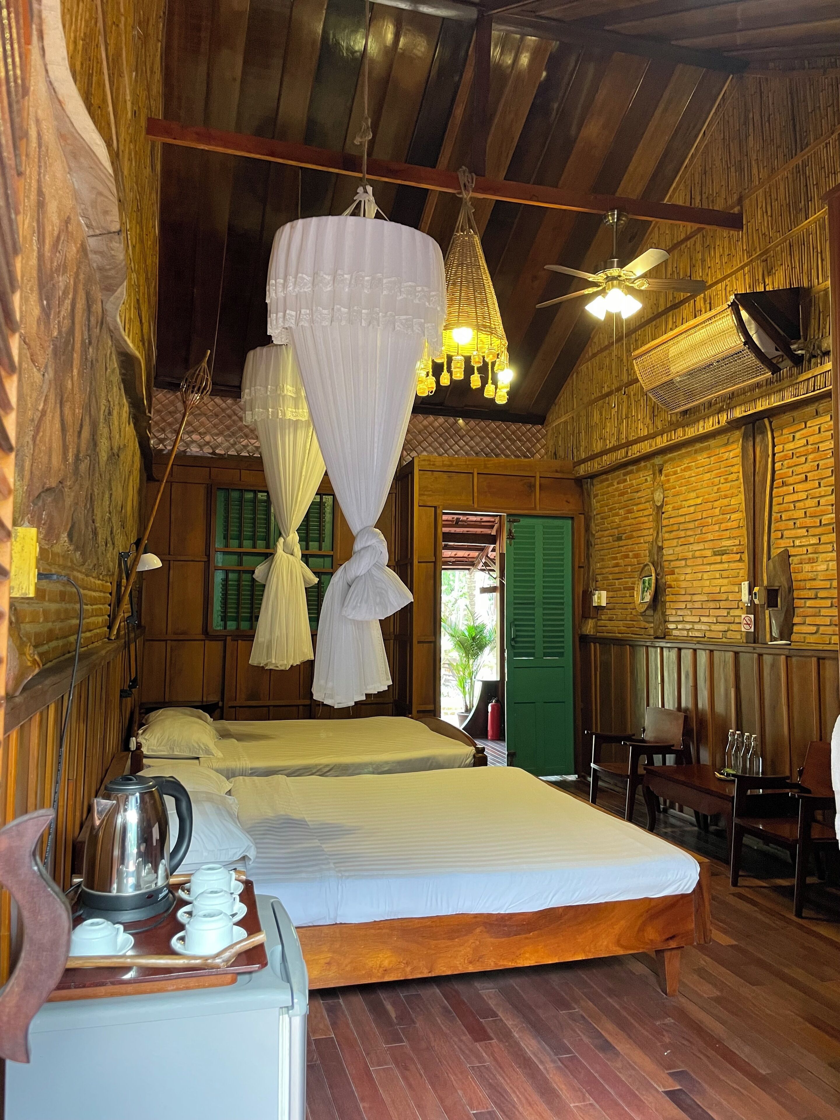 Ein traditionell eingerichteter Holzraum mit einem Bett, einem Tisch mit Wasserkocher und einer Hängelampe.