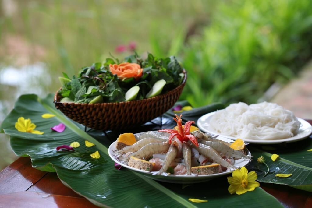 A table with a plate of grilled fish, a bowl of salad, and a plate of rice.