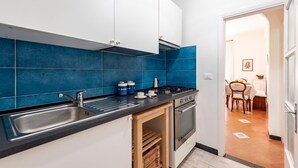 Eine moderne Küche mit weißen Schränken, einer schwarzen Arbeitsplatte und blauen Fliesen.