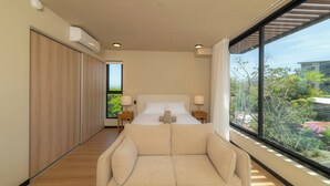 A modern hotel room with a large bed, a sofa, and a view of the outdoors. - Beautiful Studio (Santa Ana)