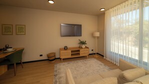 A modern living room with a wooden dining table, green chairs, a sofa, a TV mounted on the wall, and a large window with sheer curtains. - Beautiful Studio (Santa Ana)