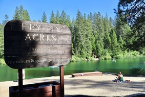 A wooden sign with 'FLY-IN ACRES' and 'Private lake' text, indicating a private lake area.