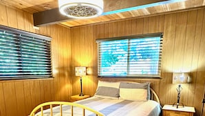 A wooden-paneled bedroom with a bed, two bedside tables, and a ceiling fan. - Creekside Cabin+Fire Pit+Lakes Nearby+Wine Tasting+Bear Valley Ski Resort (Arnold)